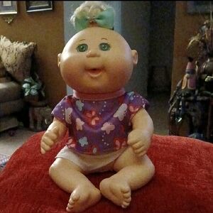 Adorable Baby Doll with Purple Outfit and Green Bow